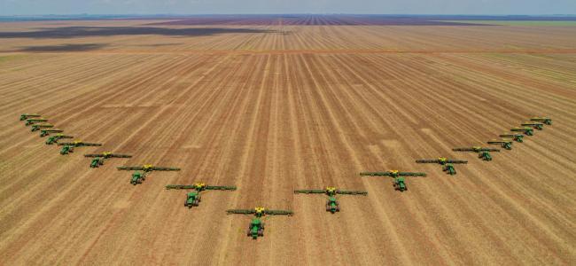 Agriculture, Aerial image, number of machines in arrow motion, front of tractors that prepare the land to sow in the field